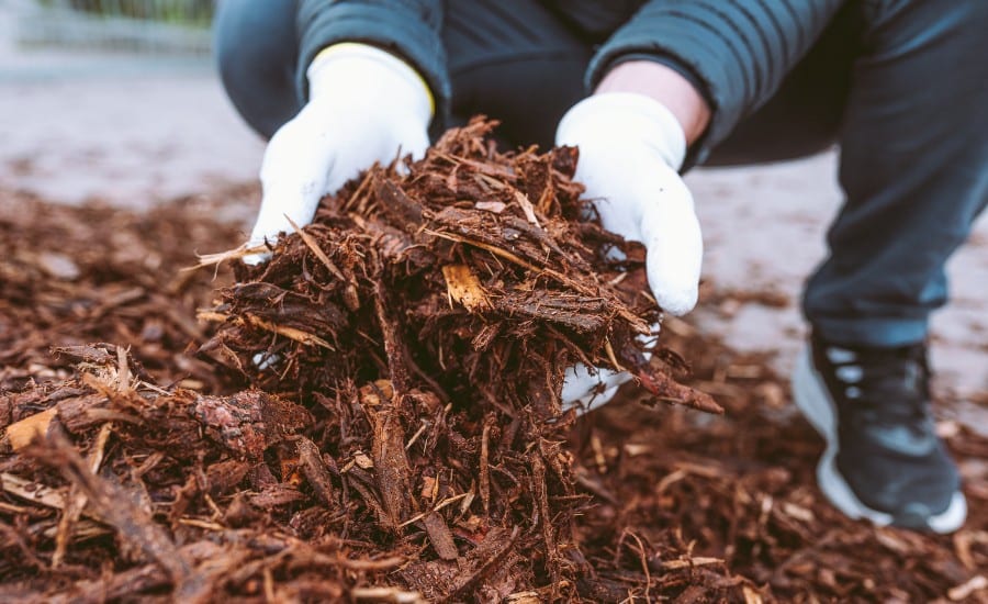 A homeowner working with organic mulch in Lake St. Louis, MO.